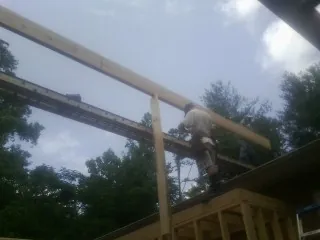 Carpenter setting a ridge beam over a new addition frame — Ice Dam Removal by Roofing Brothers in Allegan